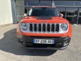 the front of an orange jeep is parked in front of a building
