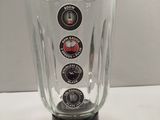 a glass blender sitting on a table with buttons on it