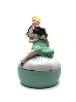 une figurine représentant une femme assise sur une boîte