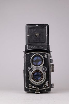 une vieille photo représentant un vieil appareil photo posé sur une surface blanche