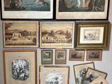 many framed pictures on the wall of a room