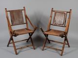 pair of wooden folding chairs with brown leather seat and back