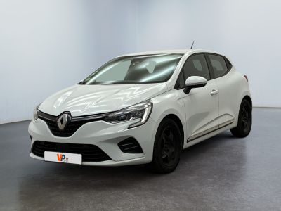 Une voiture blanche est garée dans une pièce au sol noir.