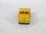 a yellow toy truck that is sitting on a white surface