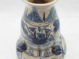 a blue and white vase sitting on a white surface