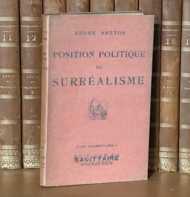 un livre rose posé sur une étagère devant une rangée de livres