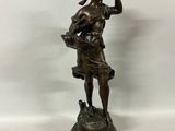 a bronze statue of a woman holding a basket of flowers