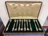 six cuillères en argent dans un coffret posé sur une table