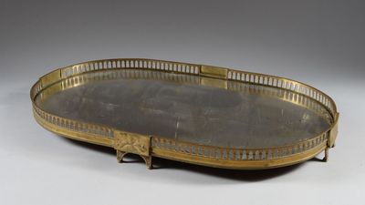 an oval brass tray with handles and handles on a white surface