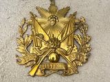 l'emblème représentant un blason de couleur dorée surmonté d'une couronne