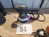 une ponceuse posée sur une table sur laquelle est inscrit le numéro 51