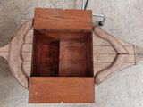 vue de dessus d'une caisse en bois munie d'une poignée, posée sur un sol en béton
