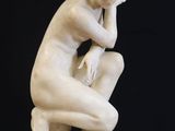 marble statue of a woman sitting on a pedestal with her hand on her chin