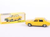 une petite voiture jaune posée à côté d'une boîte encore emballée, sur une surface blanche