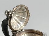 an antique silver plated teapot with a black handle on a white background