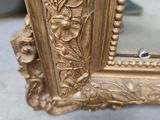 a gold frame with a picture of a woman on it