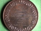 a bronze medal on a green surface that says don ' t wonder about us