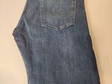 the back of a pair of jeans with a pair of scissors on a table