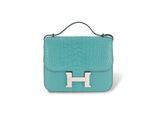 a blue handbag with a silver h logo on the front