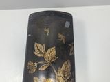 a black and gold case with flowers on it