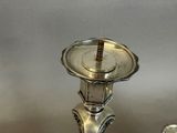 two silver candlesticks sitting next to each other on a table