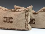 two pillows with initials on them sitting on a white surface