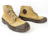 pair of yellow boots with brown soles on a white background