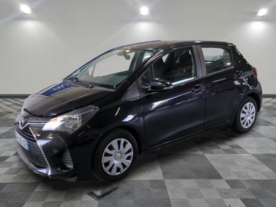 une Toyota Yaris noire garée sur un sol à damier dans un garage