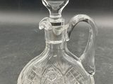 an image of a glass decanter with a handle on a table