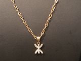 a gold necklace with a diamond cross pendant on a mannequin
