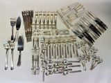 a lot of silverware on a table with forks and spoons