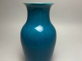 blue glass vase with a green rim on a white background