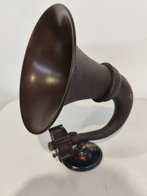 un gros plan d'un gramophone à l'ancienne posé sur une surface blanche