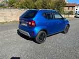 the small blue car is parked in the parking lot