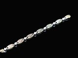 a close up of a silver bracelet on a black background