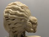 a statue of a woman with a long hair on a pedestal
