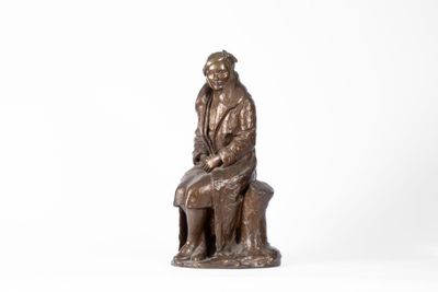 statue en bronze représentant un homme assis sur un banc avec un chien