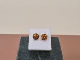 a pair of earrings sitting on top of a marble block