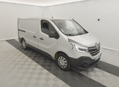 La camionnette blanche est garée dans une pièce propre au sol carrelé.
