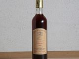 une bouteille de vin posée sur une table, avec un mur blanc en arrière-plan