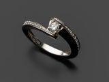 une bague en diamant noir et blanc posée sur une surface noire