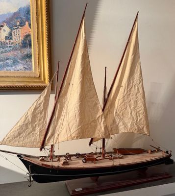 a model of a sailboat on display in front of a painting