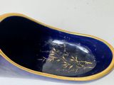 a blue bowl with a gold decoration on it
