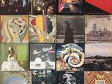 many different album covers on the wall of a room
