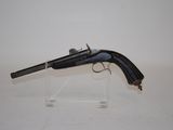 an old gun on a clear stand on a white surface