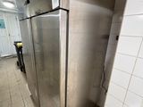 a stainless steel refrigerator in the middle of a tiled floor