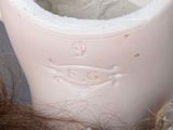 a white vase with a brown hair on a table