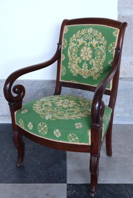 une chaise verte et dorée posée sur un sol à carreaux noirs et blancs