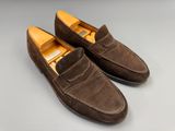 une paire de chaussures en daim marron posées sur une surface grise