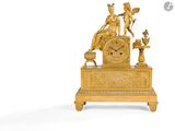 une horloge en or surmontée d'une statue